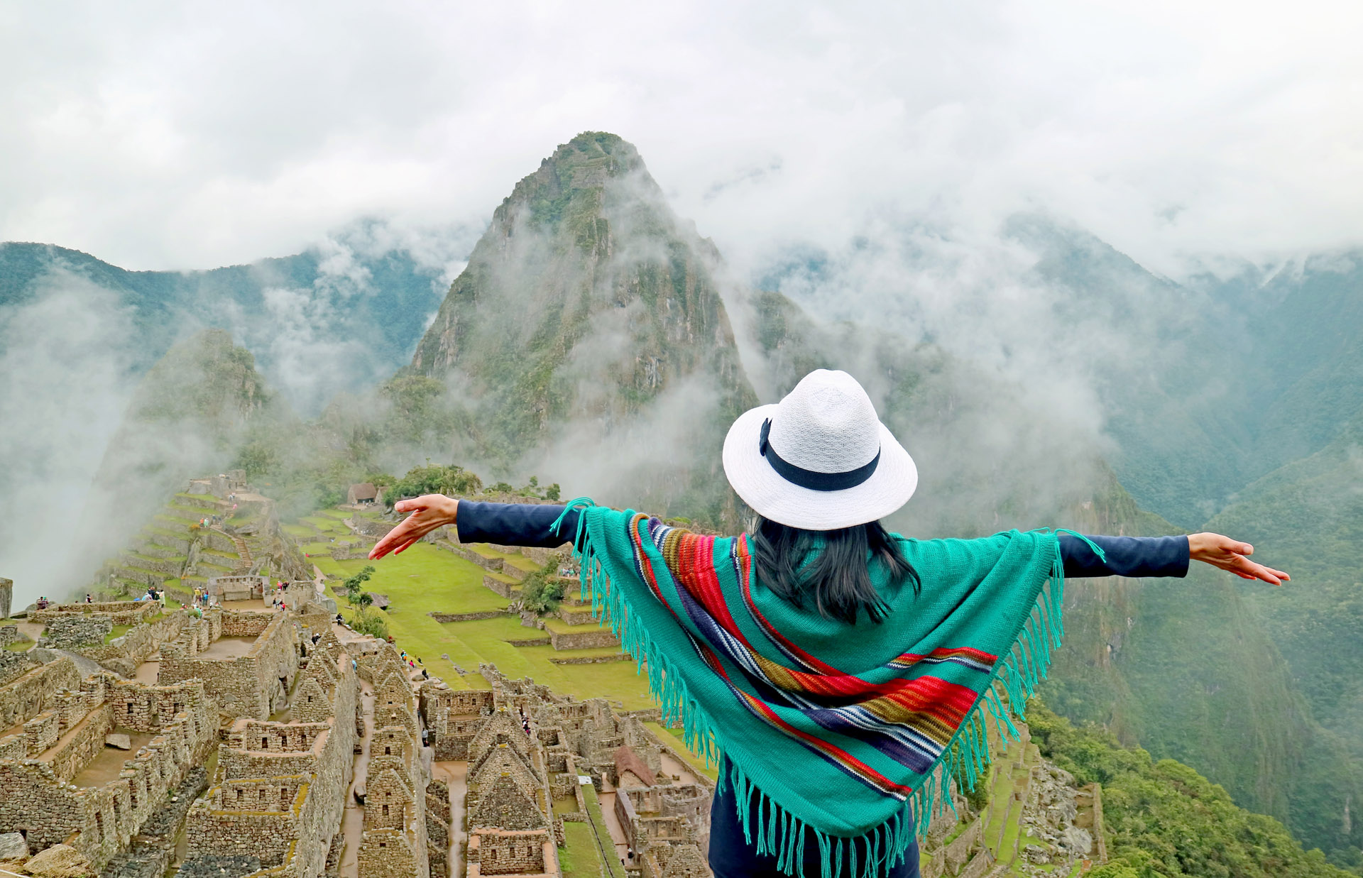 Woman in Blue Poncho Being Impressed by the Amazing Ancient Inca Citadel of Machu Picchu, UNESCO World Heritage Site in Cusco Region, Peru